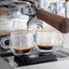 Ascaso Steel Duo V2.5 PID Dual Thermoblock Espresso Machine in white, espresso extracting into two glass cups on a scale