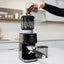 Bellucci Casa Coffee Grinder in black, filling the hopper with coffee beans