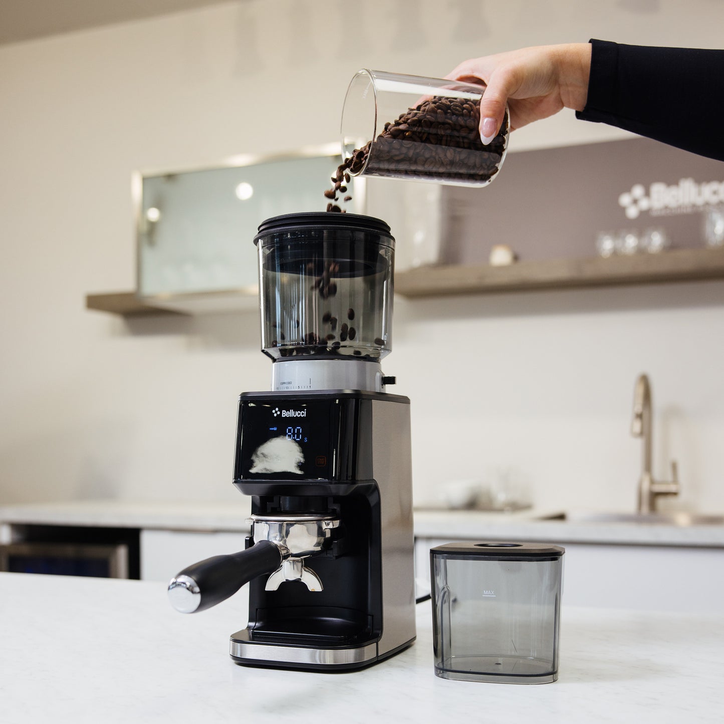 Bellucci Casa Coffee Grinder in black, grinding into a portafilter on a kitchen counter