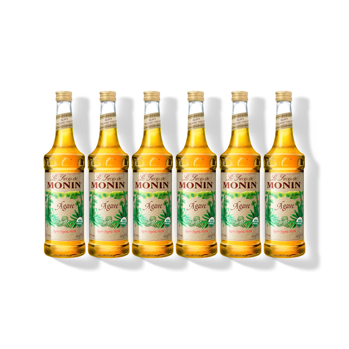 Six 750ml glass bottles of Monin Organic Agave Nectar in a row