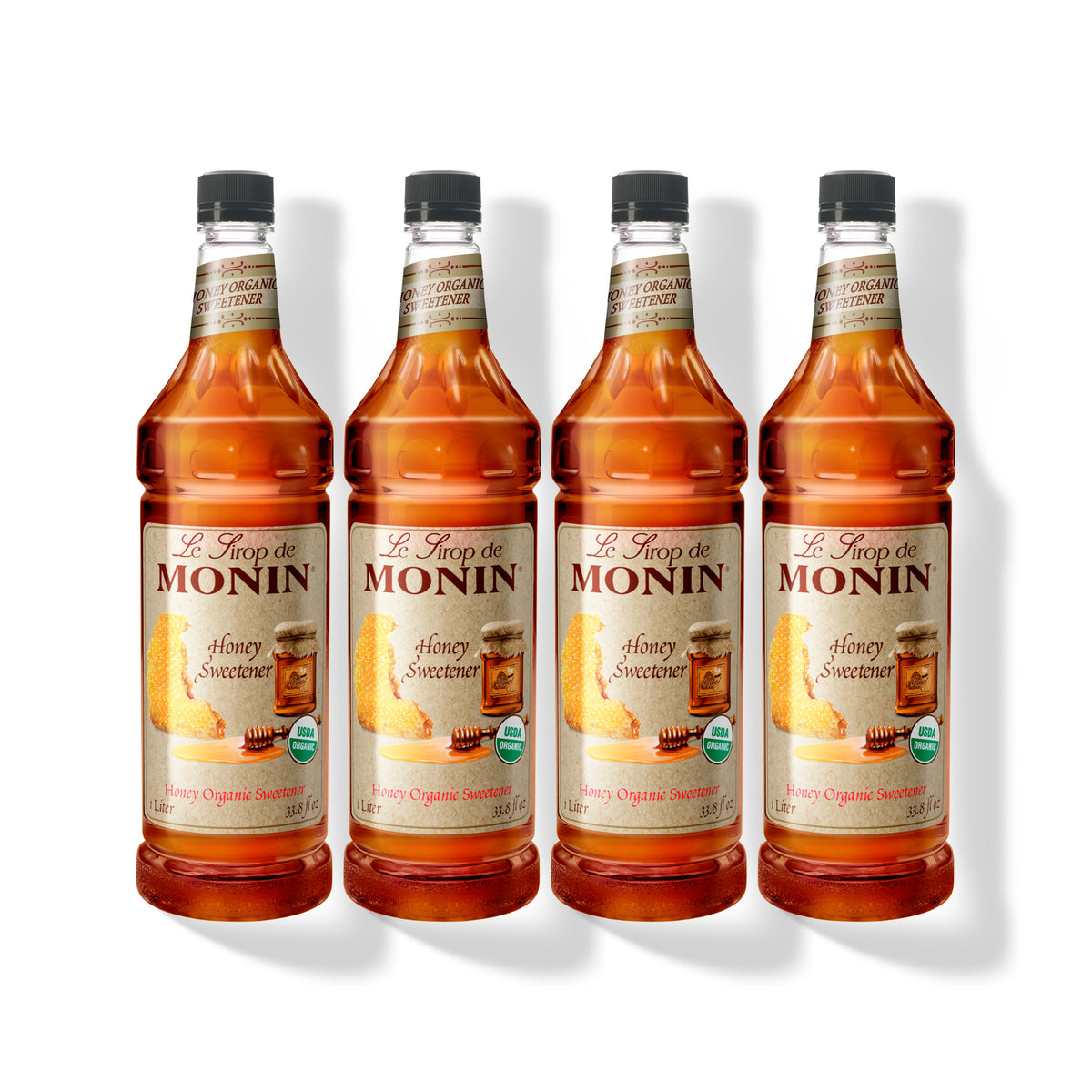Four 1L plastic bottles of Monin Honey Organic Sweetener in a row