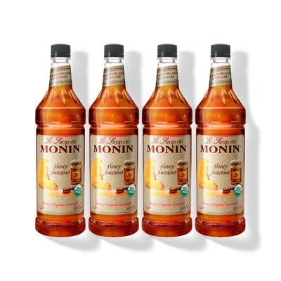 Four 1L plastic bottles of Monin Honey Organic Sweetener in a row