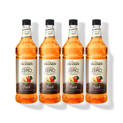 Four 1L plastic bottles of Monin Natural Zero Peach syrup in a row