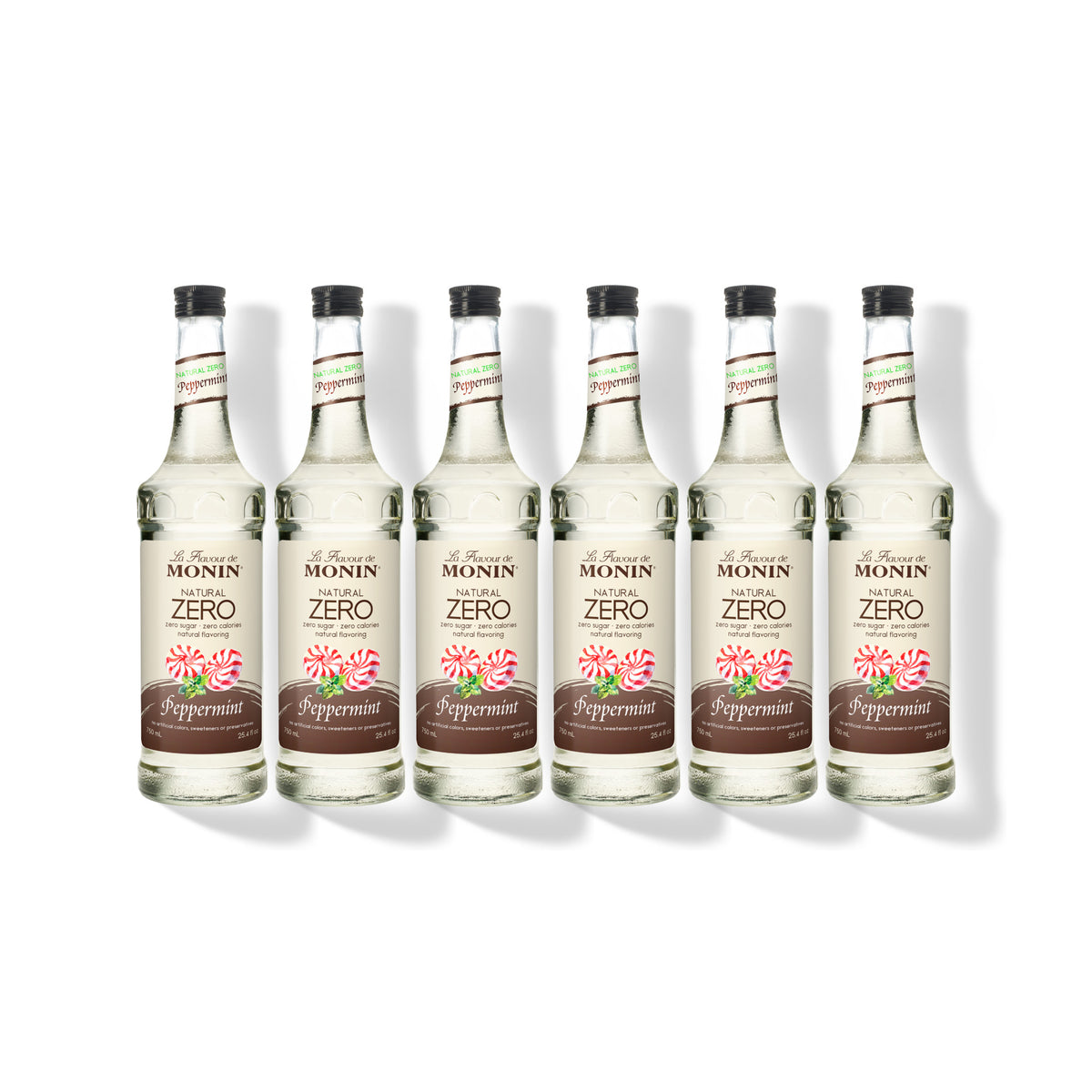 Six 750ml glass bottles of Monin Natural Zero Peppermint syrup in a row