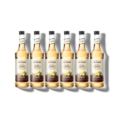 Six 750ml glass bottles of Monin Natural Zero Vanilla syrup in a row