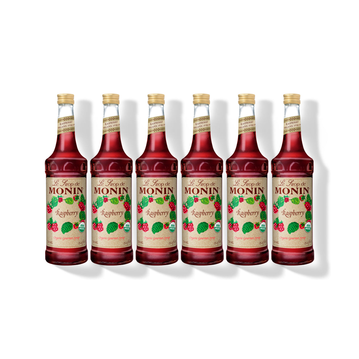 Six 750ml glass bottles of Monin Organic Raspberry syrup in a row