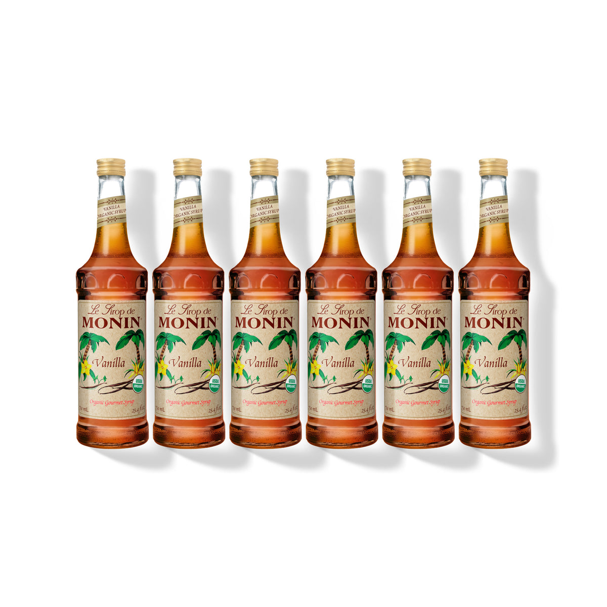 Six 750ml glass bottles of Monin Organic Vanilla syrup in a row