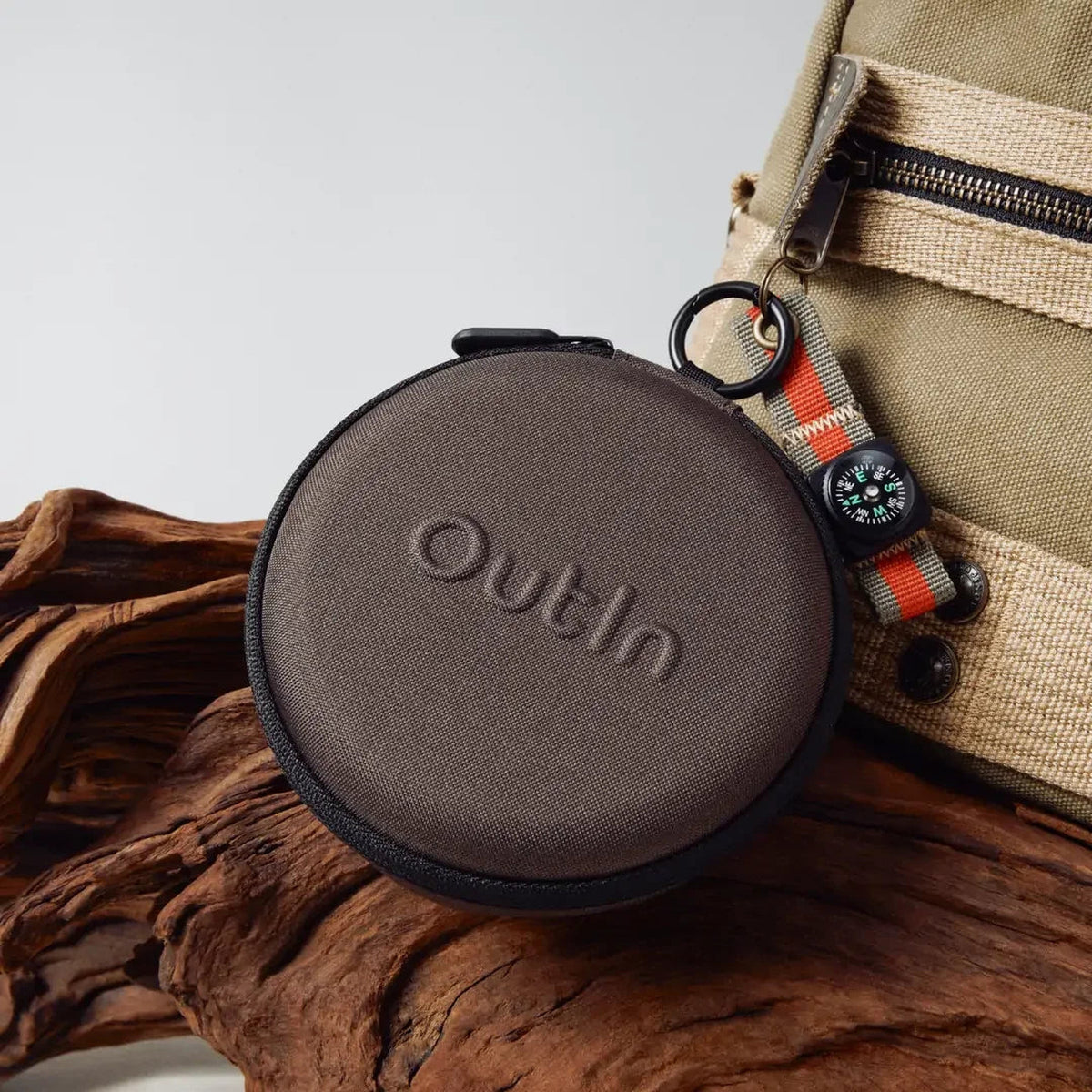 OutIn Claro Coffee Scale, packed in its case on a log beside a backpack