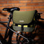 OutIn Flex Messenger Bag in cypress green, mounted on a bicycle rack