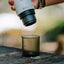 OutIn Nano Portable Espresso Machine Cup, being filled outdoors