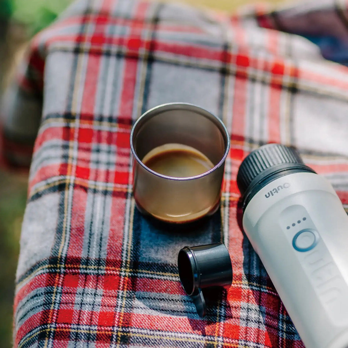OutIn Nano Portable Espresso Machine Cup, on a picnic blanket
