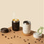 OutIn Travel Tumbler in terra brown, on a table with fresh coffee
